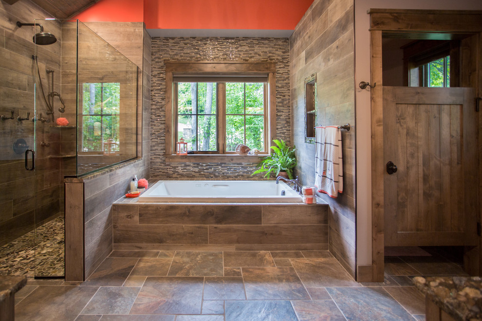 Exemple d'une grande salle de bain principale montagne avec une baignoire posée, une douche d'angle, un carrelage multicolore, des carreaux en allumettes, un mur rouge, un sol en carrelage de porcelaine, un sol multicolore et une cabine de douche à porte battante.