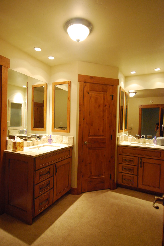 Inspiration pour une salle de bain principale traditionnelle en bois brun de taille moyenne avec un placard avec porte à panneau encastré, un plan de toilette en granite et un mur beige.
