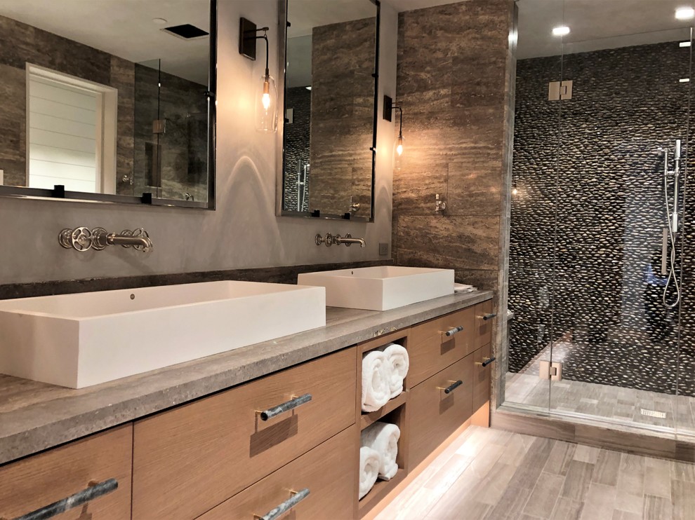 Пример оригинального дизайна: большая главная ванная комната в современном стиле с плоскими фасадами, фасадами цвета дерева среднего тона, душем в нише, раздельным унитазом, каменной плиткой, разноцветными стенами, полом из керамогранита, настольной раковиной, столешницей из бетона, серым полом, душем с распашными дверями и серой столешницей