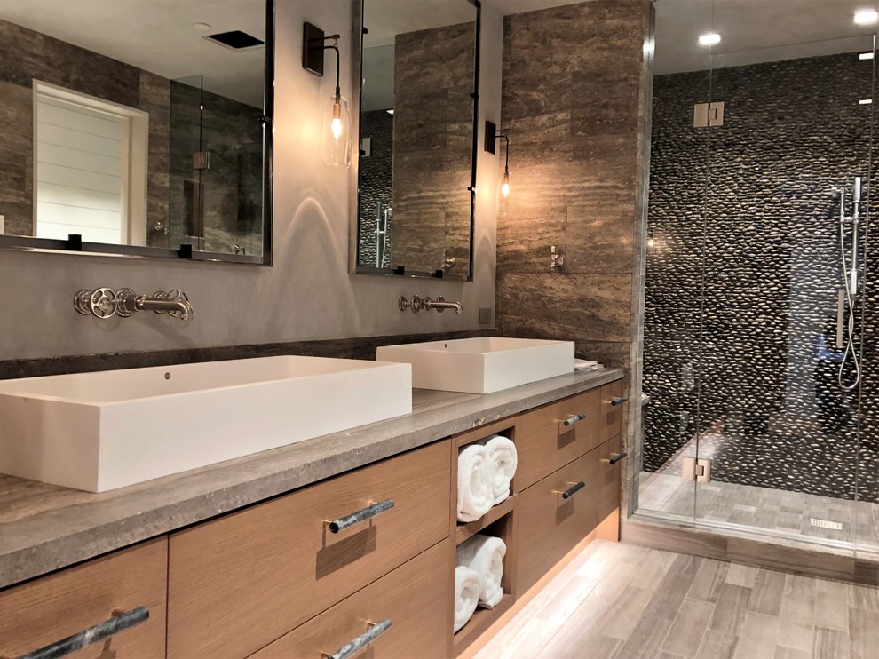 Inspiration for a large contemporary master stone tile porcelain tile and gray floor alcove shower remodel in Denver with flat-panel cabinets, medium tone wood cabinets, a two-piece toilet, multicolored walls, a vessel sink, concrete countertops, a hinged shower door and gray countertops