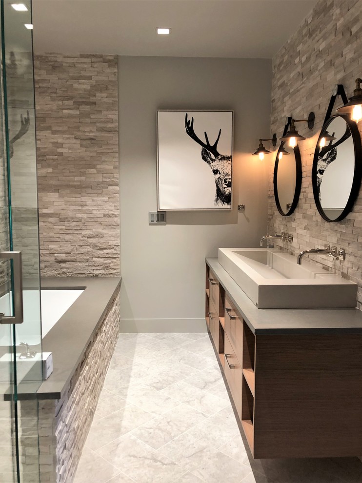 Medium sized contemporary bathroom in Denver with flat-panel cabinets, medium wood cabinets, a built-in bath, a two-piece toilet, grey walls, a vessel sink, quartz worktops, grey floors, a hinged door, grey worktops, an alcove shower, grey tiles, stone tiles and marble flooring.