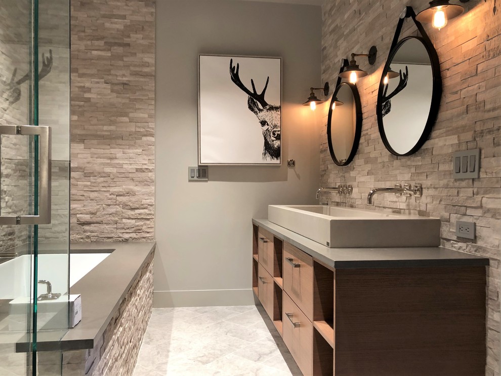 Bathroom - mid-sized contemporary gray tile and stone tile gray floor and marble floor bathroom idea in Denver with flat-panel cabinets, medium tone wood cabinets, a two-piece toilet, gray walls, a vessel sink, quartzite countertops, a hinged shower door and gray countertops
