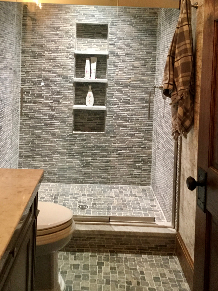 Идея дизайна: маленькая ванная комната в стиле рустика с фасадами цвета дерева среднего тона, открытым душем, раздельным унитазом, серой плиткой, каменной плиткой, полом из галечной плитки, врезной раковиной, столешницей из гранита, серым полом, душем с раздвижными дверями, серой столешницей, тумбой под одну раковину, напольной тумбой и обоями на стенах для на участке и в саду