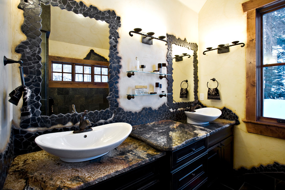 Bild på ett mellanstort rustikt flerfärgad flerfärgat en-suite badrum, med luckor med infälld panel, svarta skåp, ett platsbyggt badkar, svart kakel, skifferkakel, gula väggar, skiffergolv, ett fristående handfat, granitbänkskiva och svart golv