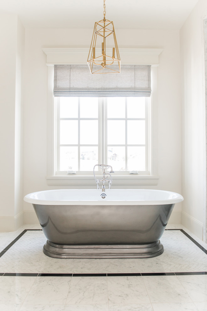 Пример оригинального дизайна: главная ванная комната среднего размера в классическом стиле с фасадами с утопленной филенкой, бежевыми фасадами, отдельно стоящей ванной, душем в нише, белой плиткой, мраморной плиткой, белыми стенами, мраморным полом, монолитной раковиной, мраморной столешницей, белым полом, душем с распашными дверями и белой столешницей