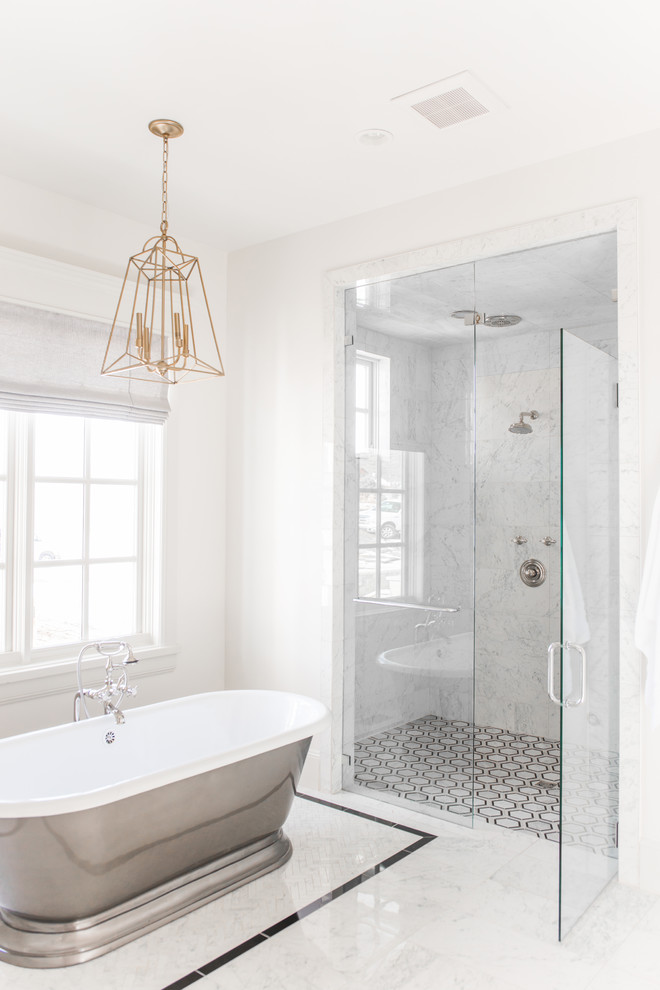 Foto på ett mellanstort vintage vit en-suite badrum, med luckor med infälld panel, beige skåp, ett fristående badkar, en dusch i en alkov, vit kakel, marmorkakel, vita väggar, marmorgolv, ett integrerad handfat, marmorbänkskiva, vitt golv och dusch med gångjärnsdörr
