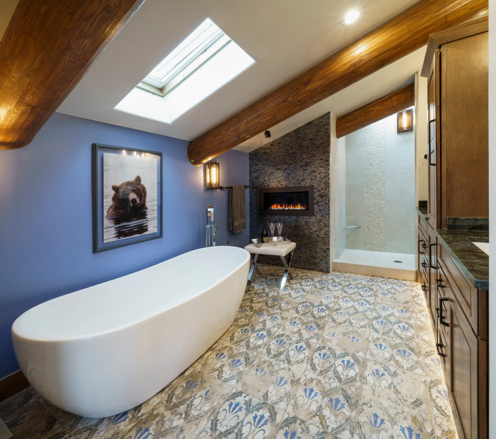 Источник вдохновения для домашнего уюта: главная ванная комната среднего размера в стиле рустика с фасадами с выступающей филенкой, коричневыми фасадами, отдельно стоящей ванной, открытым душем, инсталляцией, синей плиткой, стеклянной плиткой, синими стенами, полом из керамической плитки, врезной раковиной, столешницей из гранита, синим полом, открытым душем, синей столешницей, тумбой под две раковины, встроенной тумбой и балками на потолке