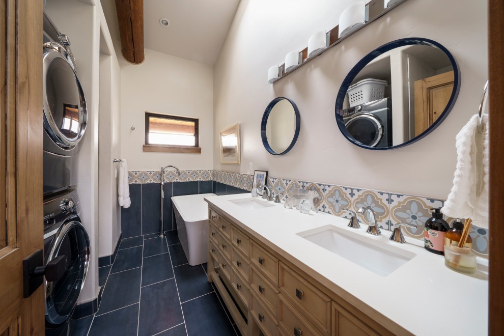 На фото: ванная комната среднего размера в стиле рустика с фасадами с выступающей филенкой, коричневыми фасадами, отдельно стоящей ванной, душем в нише, раздельным унитазом, синей плиткой, стеклянной плиткой, белыми стенами, полом из керамической плитки, врезной раковиной, столешницей из искусственного кварца, синим полом, душем с распашными дверями, белой столешницей, тумбой под две раковины, напольной тумбой и балками на потолке с