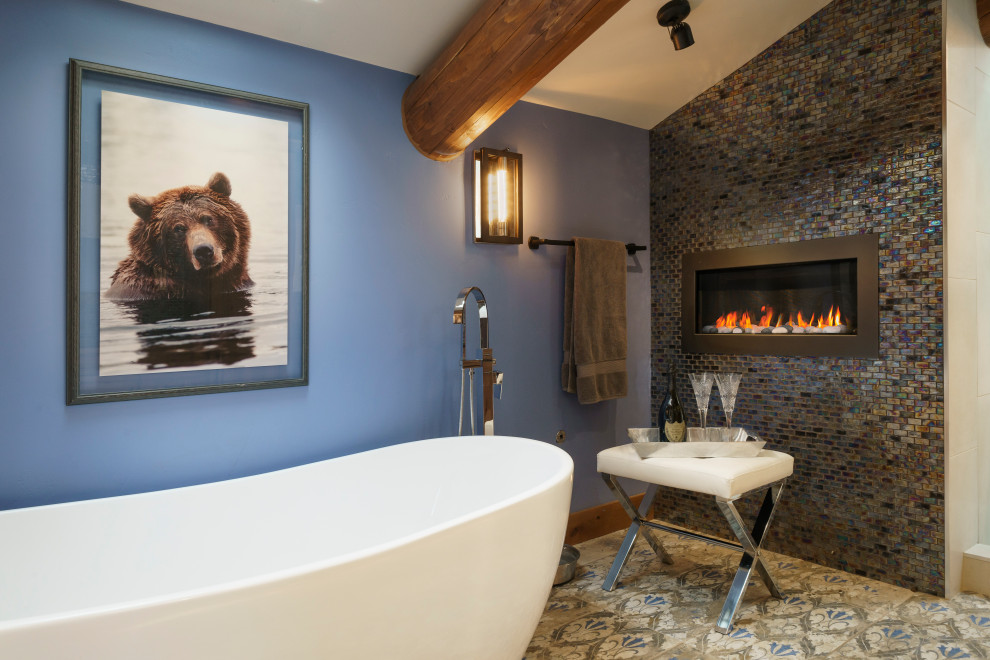 Exempel på ett mellanstort rustikt blå blått en-suite badrum, med luckor med upphöjd panel, bruna skåp, ett fristående badkar, en öppen dusch, en vägghängd toalettstol, blå kakel, glaskakel, blå väggar, klinkergolv i keramik, ett undermonterad handfat, granitbänkskiva, blått golv och med dusch som är öppen