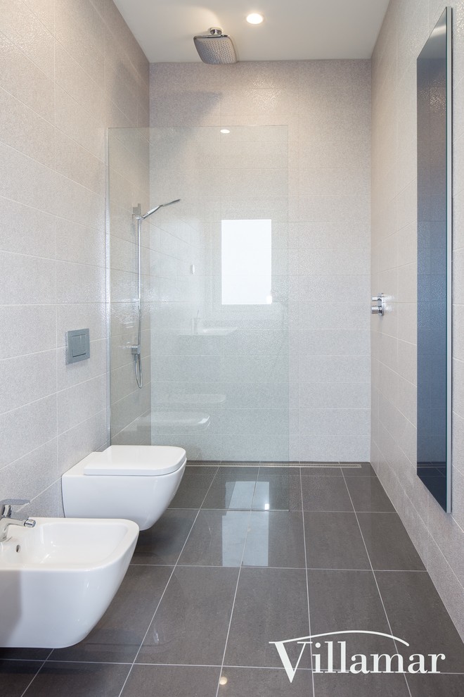 Ispirazione per una stanza da bagno con doccia minimalista di medie dimensioni con doccia a filo pavimento, WC sospeso, piastrelle grigie, piastrelle in ceramica, pareti bianche, pavimento con piastrelle in ceramica e lavabo sospeso