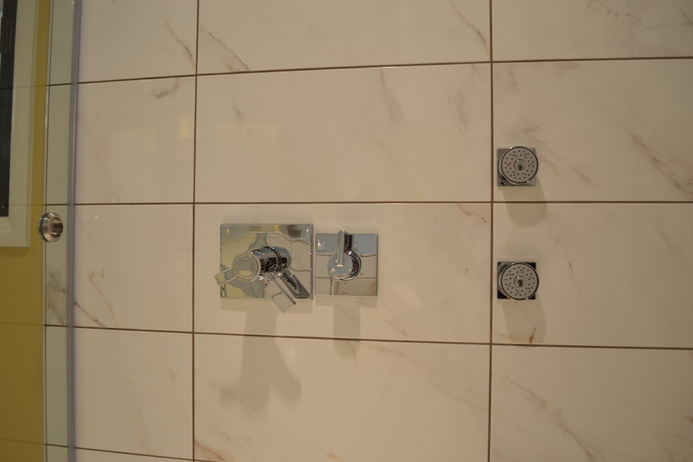 Immagine di una stanza da bagno padronale minimalista di medie dimensioni con ante lisce, ante nere, zona vasca/doccia separata, piastrelle bianche, piastrelle di marmo, pareti gialle, lavabo sottopiano, top in marmo e porta doccia a battente