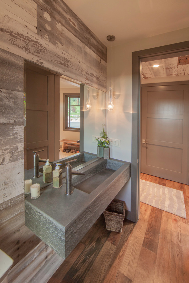 Réalisation d'une salle de bain chalet avec un lavabo intégré, un mur beige, un sol en bois brun et un plan de toilette en béton.