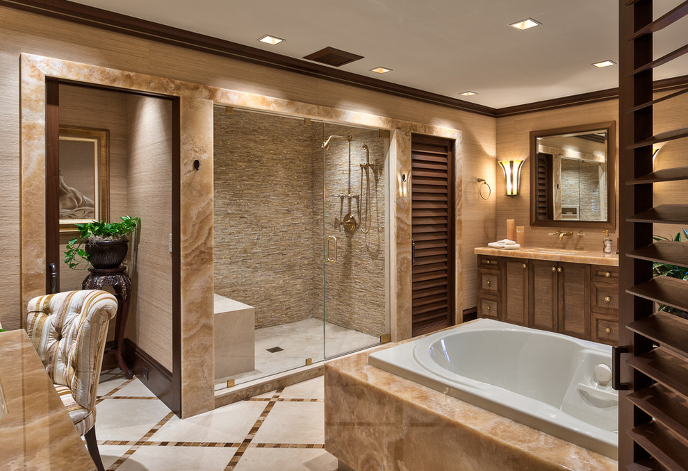 Aménagement d'une grande douche en alcôve principale classique en bois brun avec un lavabo encastré, une baignoire posée, un carrelage beige, un placard à porte shaker, des dalles de pierre, un mur beige, un sol en marbre et un plan de toilette en marbre.