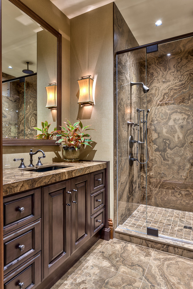 Rustik inredning av ett brun brunt badrum, med ett undermonterad handfat, luckor med upphöjd panel, skåp i mörkt trä, en dusch i en alkov, brun kakel och brunt golv