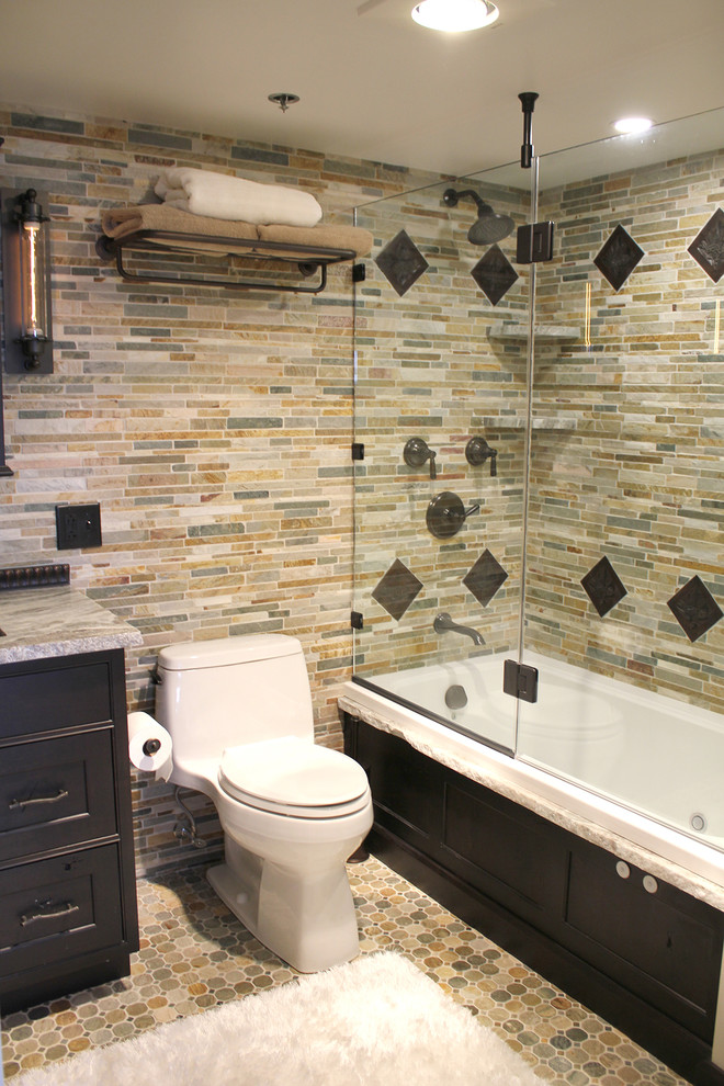 Mid-sized elegant master multicolored tile and stone tile ceramic tile and multicolored floor bathroom photo in Boston with beaded inset cabinets, brown cabinets, a one-piece toilet, multicolored walls, an undermount sink, marble countertops, a hinged shower door and multicolored countertops