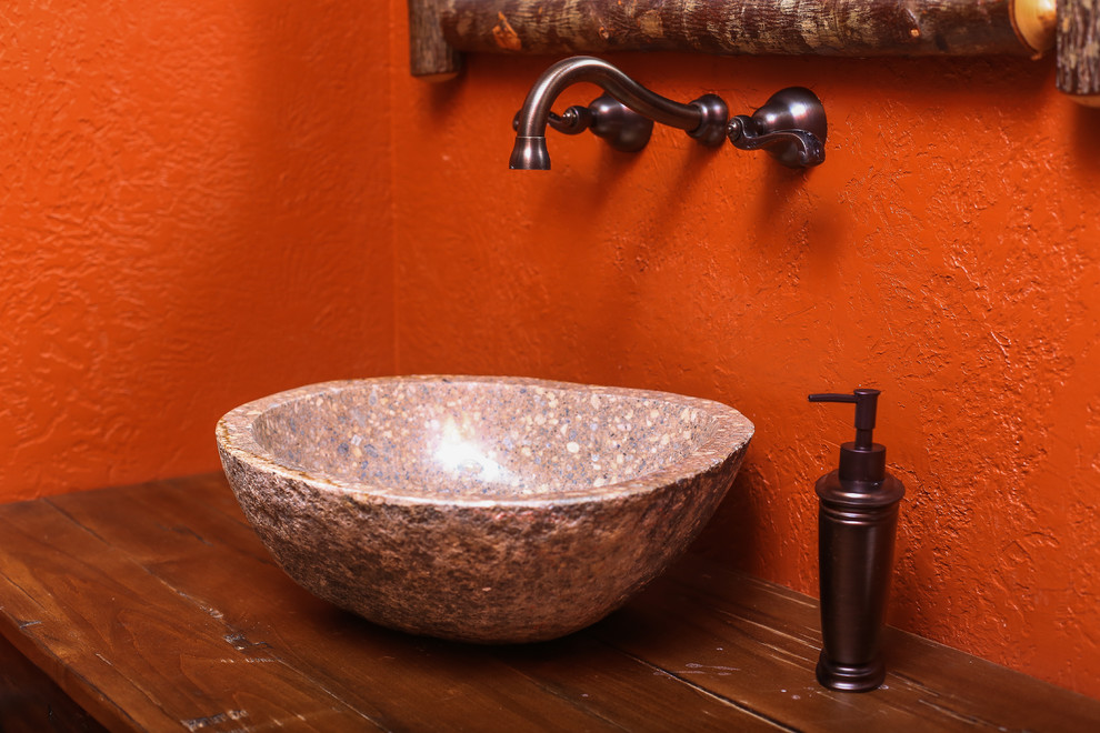 Foto di una stanza da bagno con doccia stile rurale di medie dimensioni con pareti arancioni, ante con finitura invecchiata, lavabo a bacinella e top in legno