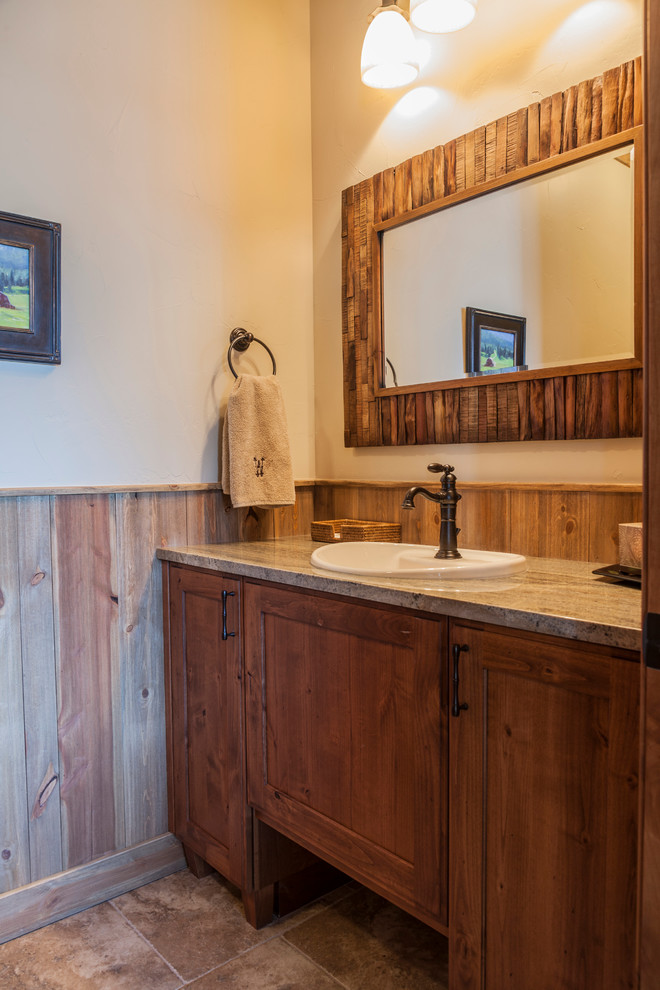 Modelo de cuarto de baño rural con armarios estilo shaker, puertas de armario de madera oscura, baldosas y/o azulejos beige, baldosas y/o azulejos de piedra, paredes beige, suelo de travertino, lavabo encastrado y encimera de granito