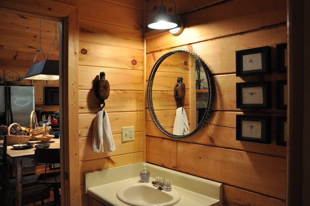 This is an example of a small rustic shower room bathroom in Atlanta with flat-panel cabinets, light wood cabinets, an alcove bath, a shower/bath combination, a two-piece toilet, light hardwood flooring, a built-in sink and laminate worktops.