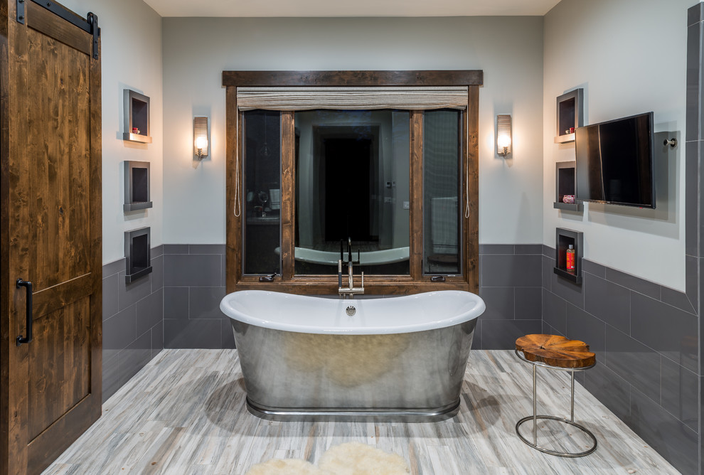 Immagine di una stanza da bagno padronale rustica di medie dimensioni con vasca freestanding, piastrelle grigie, pareti grigie, pavimento in gres porcellanato e pavimento multicolore