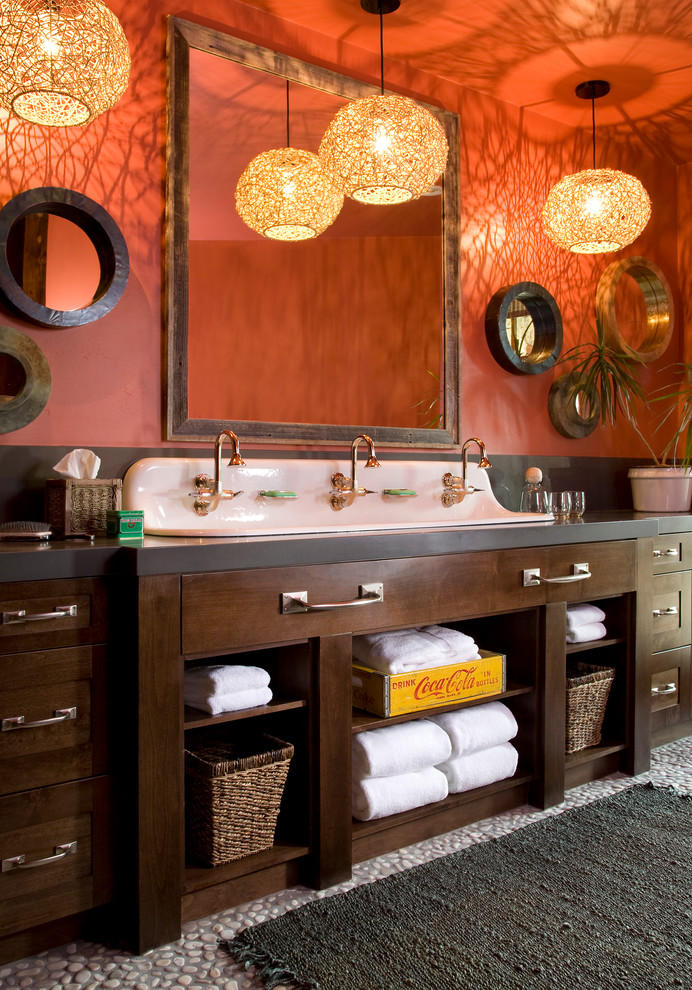 Imagen de cuarto de baño rural con lavabo de seno grande, puertas de armario de madera en tonos medios, parades naranjas, armarios estilo shaker y encimeras grises