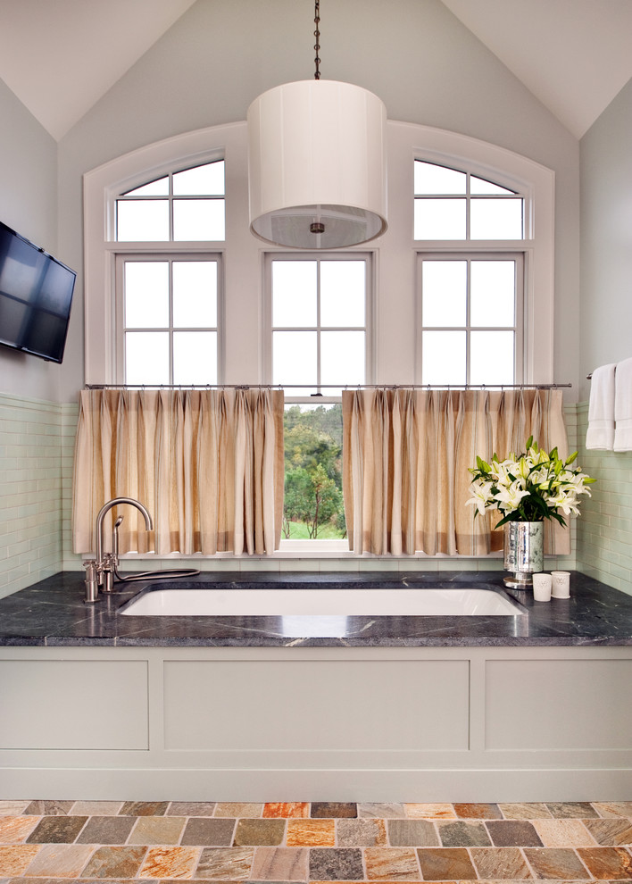 Mid-sized transitional master stone tile bathroom photo in Richmond with soapstone countertops, an undermount tub and gray walls