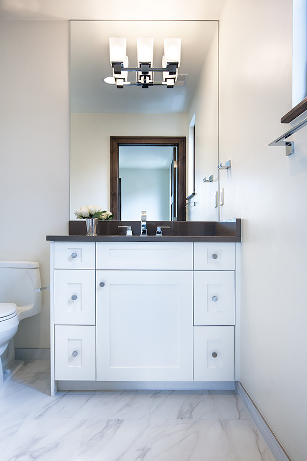 Modelo de cuarto de baño actual de tamaño medio con armarios estilo shaker, puertas de armario blancas y aseo y ducha