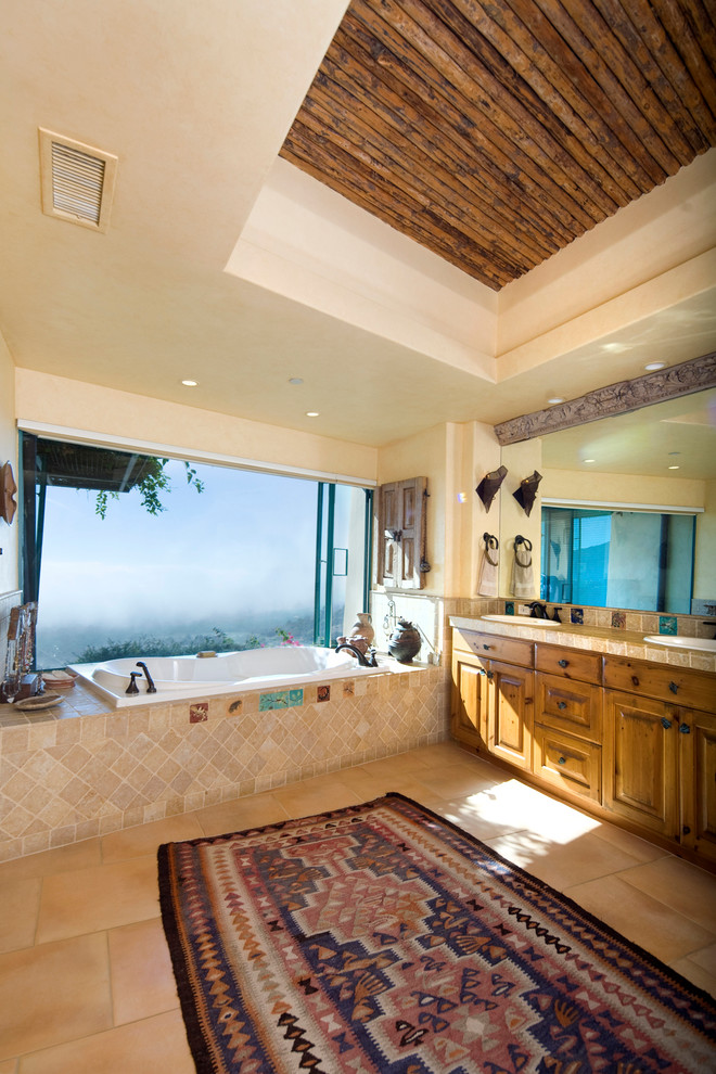 Exemple d'une grande salle de bain principale sud-ouest américain en bois brun avec un placard à porte shaker, un plan de toilette en carrelage, une douche ouverte, un carrelage beige, des carreaux de céramique, un lavabo posé, une baignoire posée, un mur beige et un sol en carrelage de céramique.