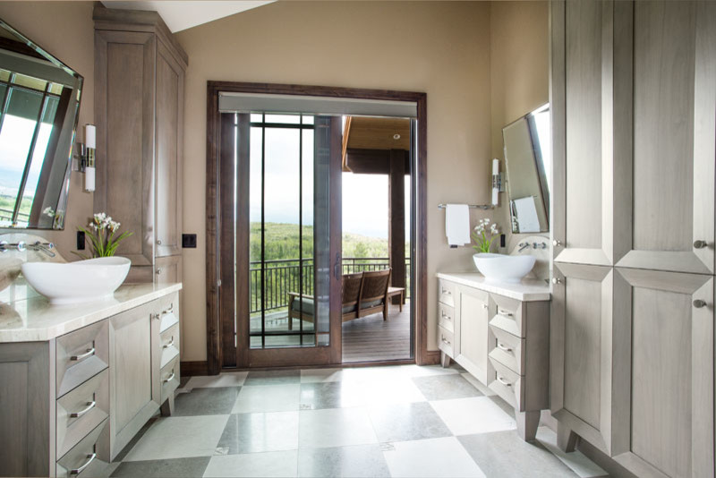 Cette photo montre une grande salle de bain principale chic en bois clair avec un placard avec porte à panneau surélevé, un mur beige, une vasque et un sol gris.
