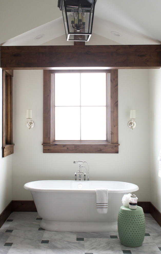 Cette image montre une salle de bain principale chalet avec une baignoire indépendante, un mur blanc et un sol multicolore.