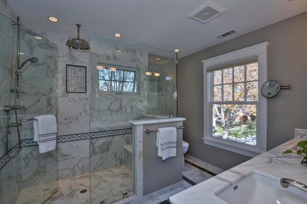 Immagine di una stanza da bagno classica con lavabo sottopiano, ante in stile shaker, ante bianche, top in marmo, WC a due pezzi, piastrelle bianche e piastrelle in pietra