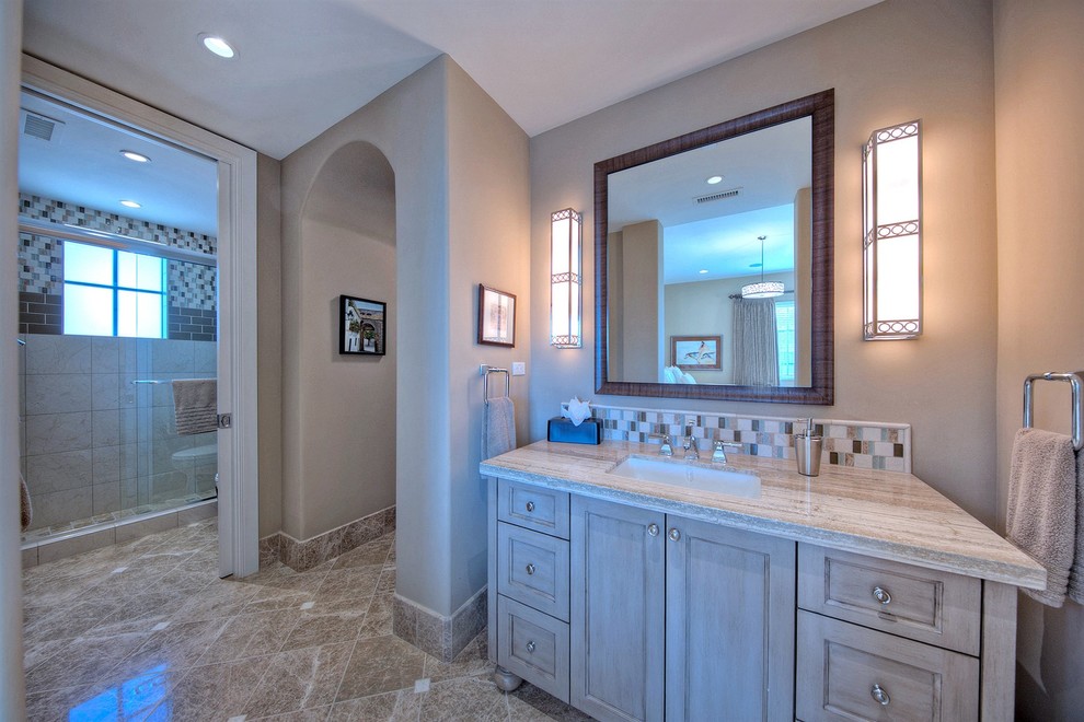Immagine di una stanza da bagno con doccia mediterranea di medie dimensioni con ante in legno chiaro