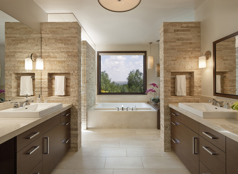 Exempel på ett modernt badrum, med ett fristående handfat, släta luckor, skåp i mörkt trä, ett platsbyggt badkar, en dusch i en alkov, beige kakel, beige väggar och beiget golv