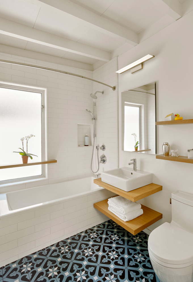 Свежая идея для дизайна: ванная комната в современном стиле с ванной в нише, душем над ванной, раздельным унитазом, белой плиткой, плиткой кабанчик, белыми стенами, настольной раковиной, синим полом и шторкой для ванной - отличное фото интерьера