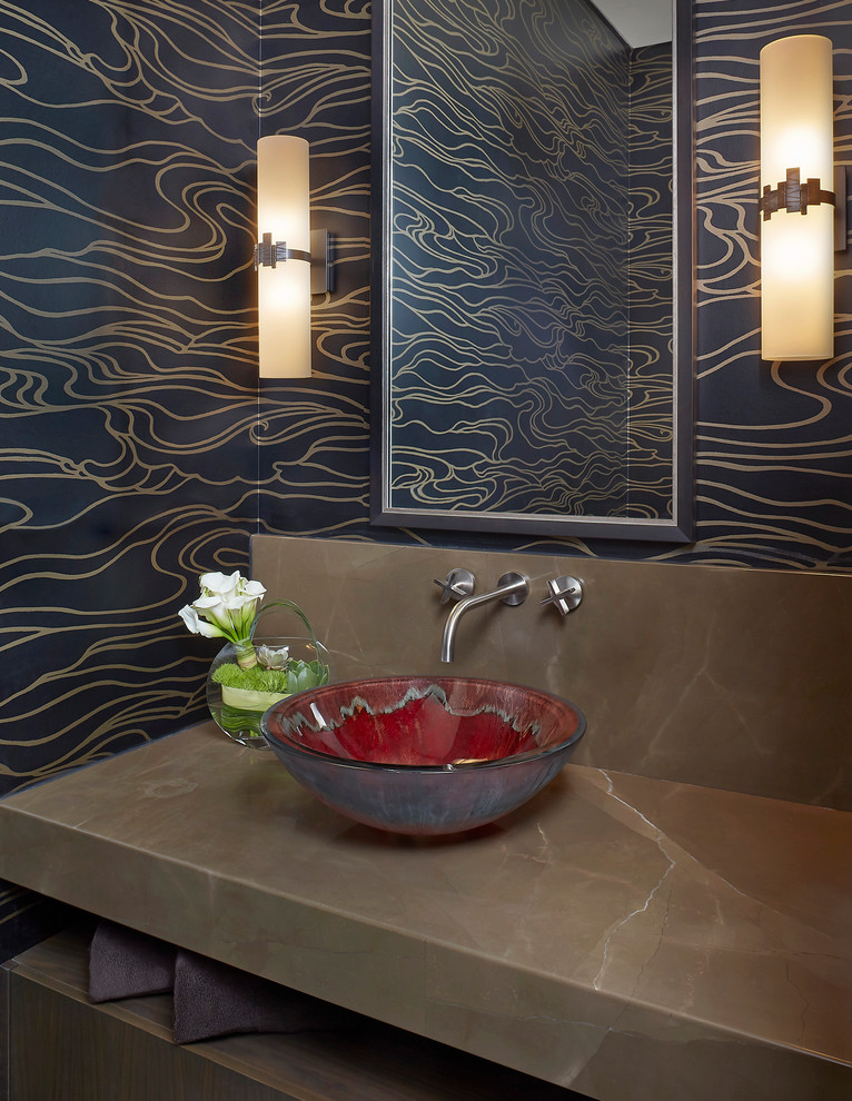 Idée de décoration pour une très grande salle de bain design avec un mur noir, un sol en calcaire, une vasque et un plan de toilette en calcaire.