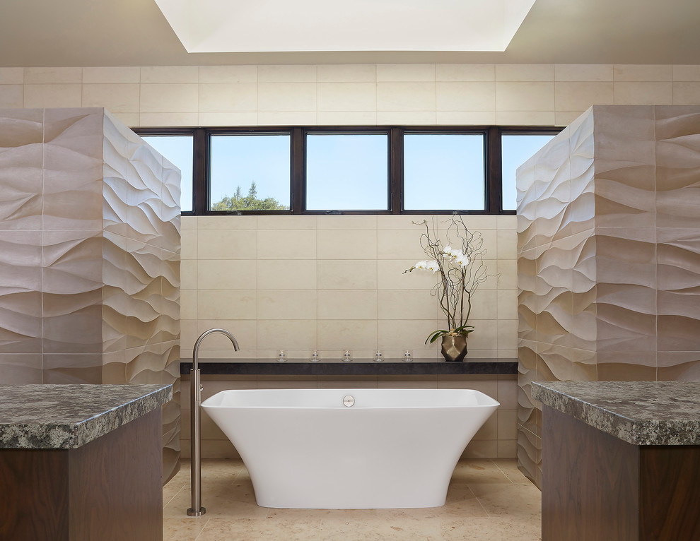 Idée de décoration pour une très grande salle de bain principale design en bois foncé avec une baignoire indépendante, un carrelage gris, un carrelage de pierre, un mur beige, un sol en calcaire, un lavabo encastré et un plan de toilette en granite.