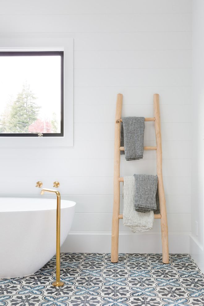 Esempio di una stanza da bagno country con vasca freestanding, pareti bianche e pavimento in cementine