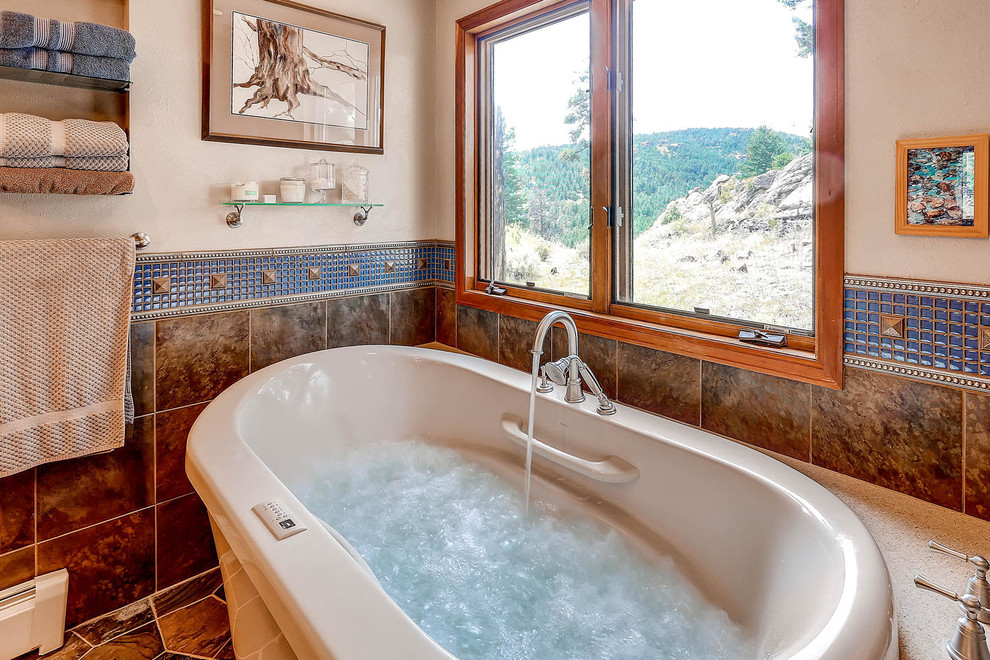 Exempel på ett stort rustikt en-suite badrum, med släta luckor, skåp i ljust trä, ett fristående badkar, en dubbeldusch, blå kakel, mosaik, beige väggar, betonggolv, ett undermonterad handfat och bänkskiva i kalksten