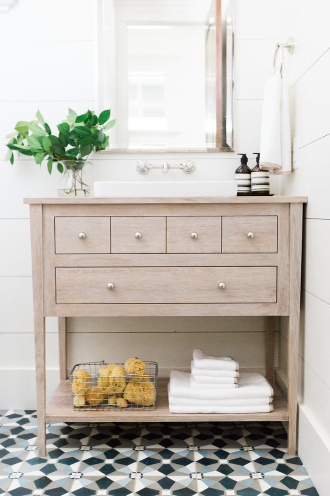 Imagen de cuarto de baño clásico con paredes blancas, suelo de azulejos de cemento, lavabo tipo consola y suelo multicolor