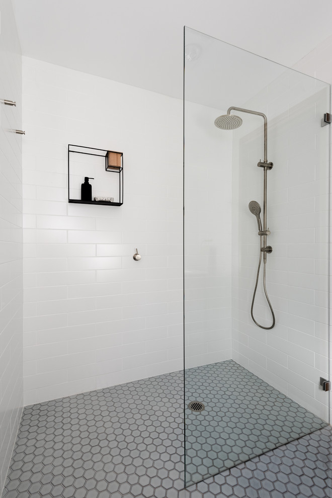Idéer för att renovera ett mellanstort 60 tals vit vitt en-suite badrum, med släta luckor, svarta skåp, en dusch i en alkov, en vägghängd toalettstol, vit kakel, keramikplattor, vita väggar, mosaikgolv, ett väggmonterat handfat, grått golv och med dusch som är öppen
