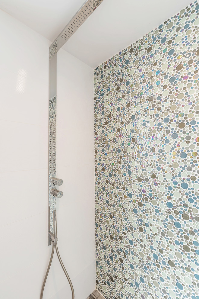 Bild på ett litet funkis badrum med dusch, med släta luckor, en dusch i en alkov, en toalettstol med hel cisternkåpa, glaskakel, vita väggar, klinkergolv i porslin, ett väggmonterat handfat, grått golv och dusch med gångjärnsdörr