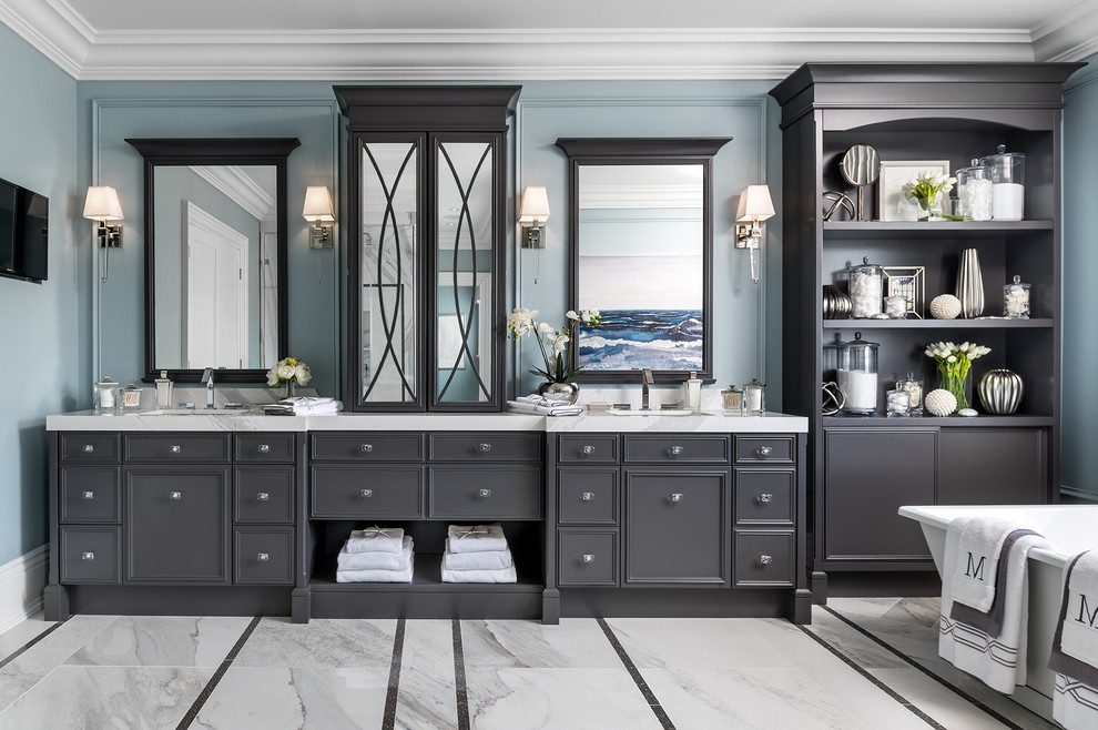 На фото: главная ванная комната в классическом стиле с серыми фасадами, отдельно стоящей ванной, синими стенами, врезной раковиной и фасадами с утопленной филенкой