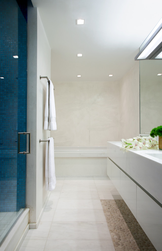 Ispirazione per una stanza da bagno moderna di medie dimensioni con ante lisce, ante bianche, vasca ad alcova, doccia ad angolo, piastrelle bianche, pareti bianche, pavimento in marmo, lavabo integrato e porta doccia a battente