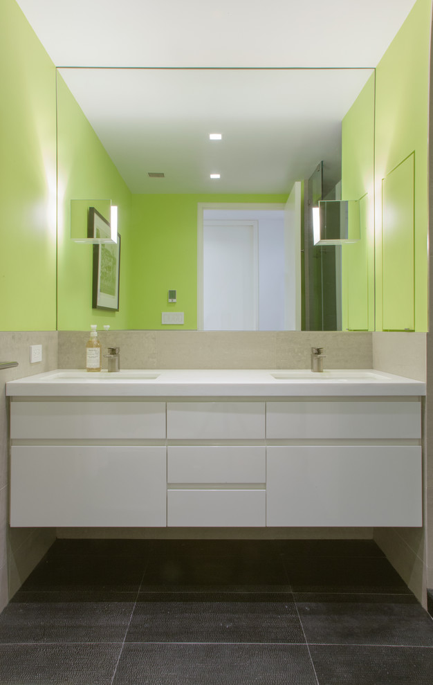 На фото: ванная комната среднего размера в стиле модернизм с плоскими фасадами, белыми фасадами, зелеными стенами и монолитной раковиной с