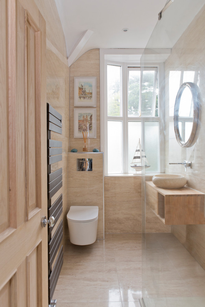 На фото: ванная комната в современном стиле с плоскими фасадами, фасадами цвета дерева среднего тона, бежевыми стенами, настольной раковиной, столешницей из дерева, бежевым полом, тумбой под одну раковину и подвесной тумбой с