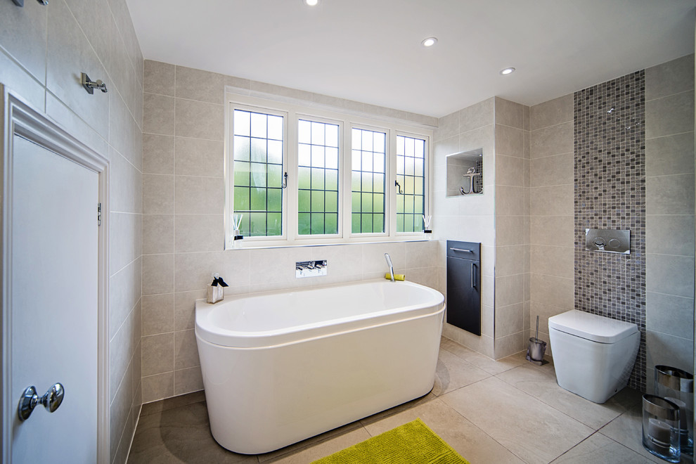 Medium sized contemporary ensuite bathroom in Surrey with grey cabinets, a freestanding bath and a walk-in shower.