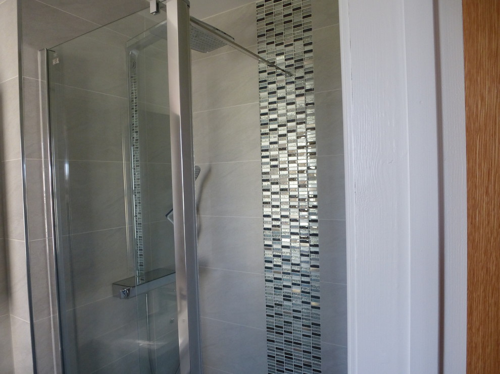Immagine di una stanza da bagno moderna con vasca idromassaggio, WC sospeso, piastrelle beige e pareti beige