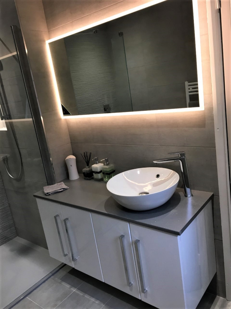 Doorless shower - modern kids' gray tile and porcelain tile gray floor and porcelain tile doorless shower idea in West Midlands with flat-panel cabinets, white cabinets, a vessel sink and gray countertops