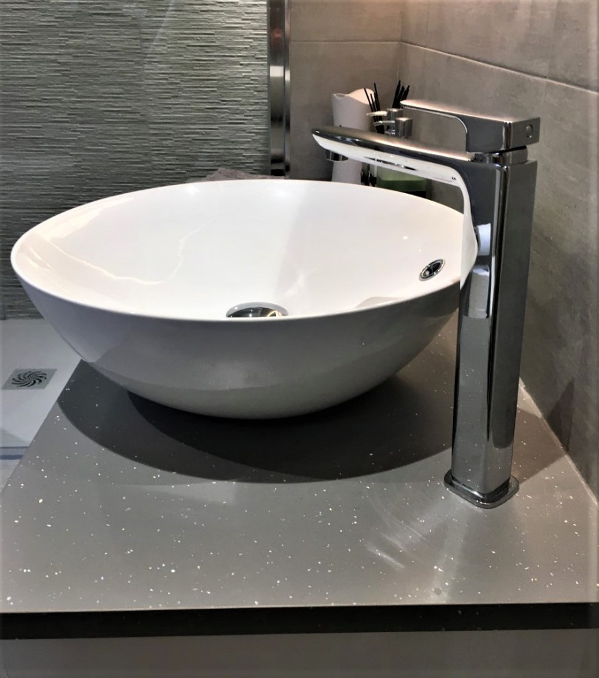 Inspiration för moderna grått badrum med dusch, med släta luckor, vita skåp, en öppen dusch, grå kakel, porslinskakel, klinkergolv i porslin, ett fristående handfat och grått golv