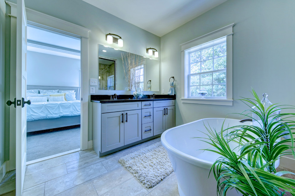 Exempel på ett mellanstort klassiskt en-suite badrum, med luckor med infälld panel, grå skåp, ett fristående badkar, en öppen dusch, en toalettstol med separat cisternkåpa, beige kakel, keramikplattor, grå väggar, klinkergolv i keramik, ett undermonterad handfat och granitbänkskiva