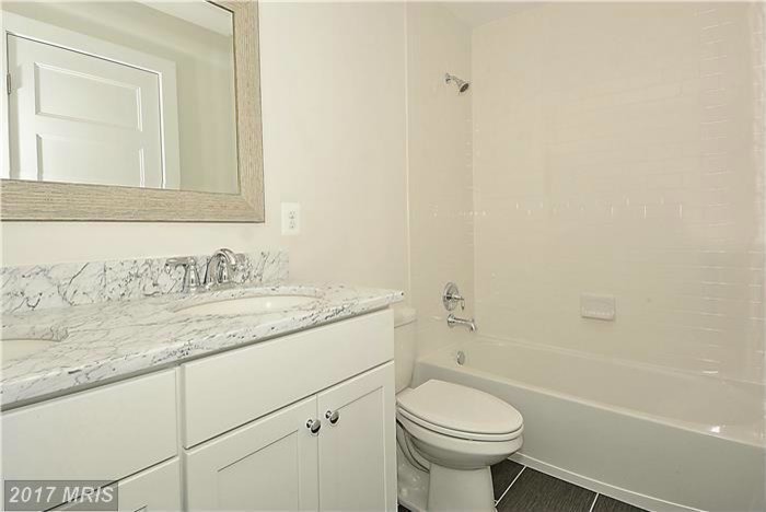 Example of a mid-sized classic kids' white tile and subway tile porcelain tile and gray floor bathroom design in Baltimore with shaker cabinets, white cabinets, a two-piece toilet, white walls, an undermount sink and solid surface countertops